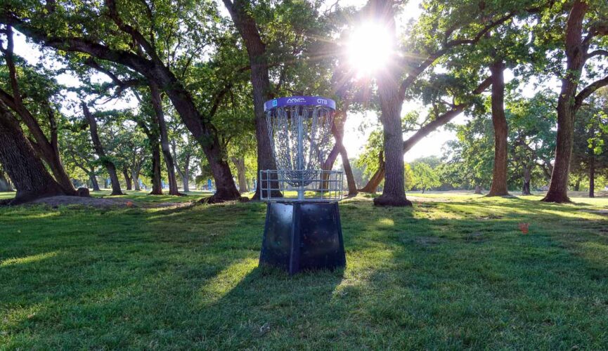 A photo of a disc golf basket during sunset